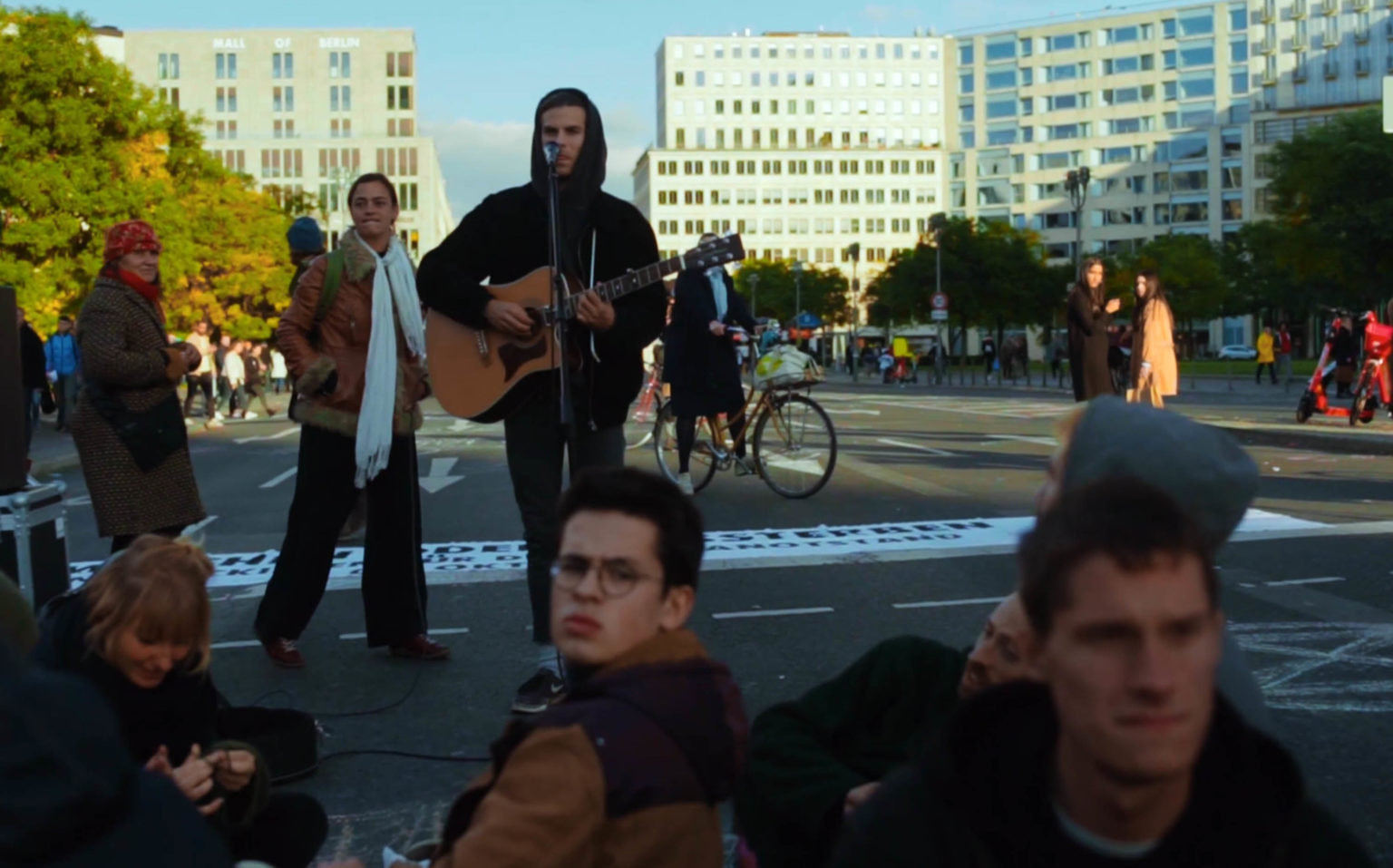 Leo Holldack singt für Aktivisten der Extinction Rebellion mit Gitarre auf Potsdamer Platz